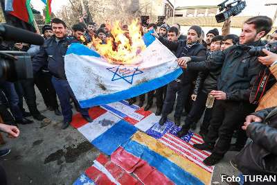 Residents of the village of Nardaran burn the flags of France, Israel and the US 